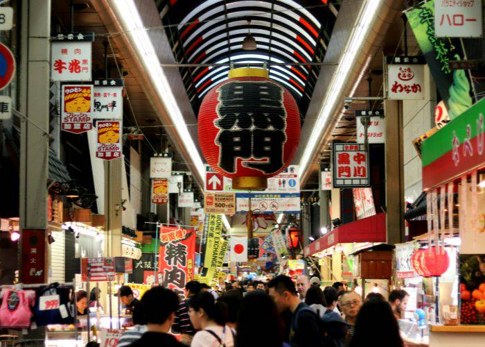 The crowded stalls and vendors of Kuromon Market in Osaka.